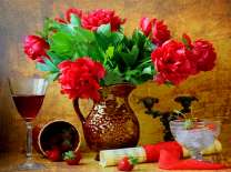 Букет пионов, бокал вина и письмо на столе