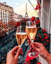 Два бокала шампанского на фоне Эйфелевой башни