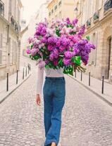 Девушка в городе с большим букетом сирени