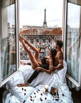 Девушка с парнем на балконе с видом на Эйфелеву башню