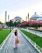 Девушка гуляет по саду у мечети