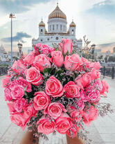 Букет розовых роз на фоне храма