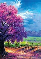 Дерево с фиолетовым цветом на фоне гор