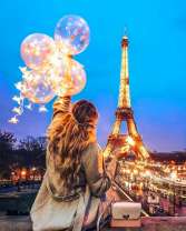 Девушка с шариками и цветами на фоне Эйфелевой башни