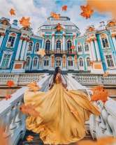 Девушка в осеннем платье на фоне здания