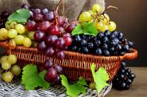 Плетёная корзинка с разными сортами винограда