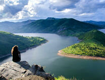 Девушка на скале над большой рекой