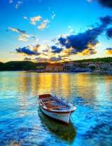 Лодка в море на фоне деревни