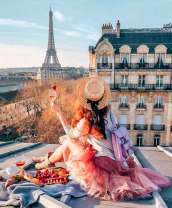 Девушка с шампанским и сладостями на крыше Парижа