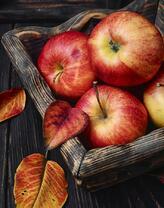 Осенние яблоки в деревянной тарелке