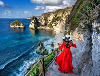 Девушка в красном на горной тропе к морю