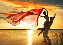 Влюбленные радуются закату на берегу моря