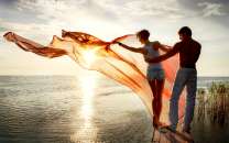 Пара у моря на фоне солнца