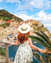 Рыжеволосая девушка смотрит на морской городок