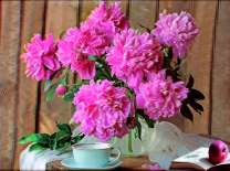 Яркий букет пионов и чашечка чая