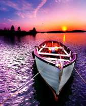 Белая лодка на фоне заходящего солнца