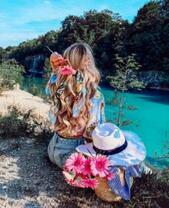 Девушка с букетом гербер у кристального озера