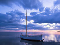 Лодка со спущенным парусом в море