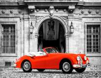 Красный спортивный автомобиль у дворца