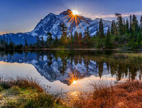 Солнце над горой у озера