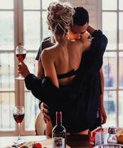 Влюбленная пара с вином на кухне